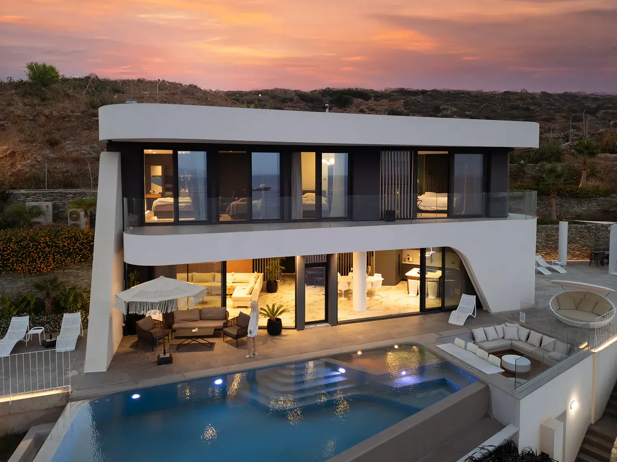 Meltemi Villa at twilight with illuminated infinity pool and sea view, Crete