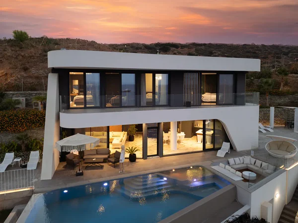 Twilight villa with illuminated pool at sunset